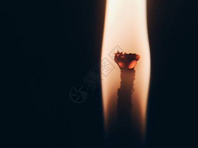 点燃热火的蜡烛在模糊的黑色图片