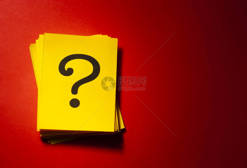 黄色纸卡上的问号和深红色背景图片