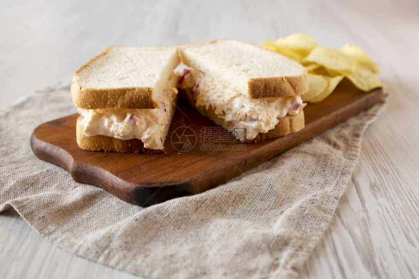美味自制的Pimmento奶酪三明治和薯片在生锈木板上图片