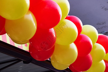 建筑物上的黄色和红色气球特写图片