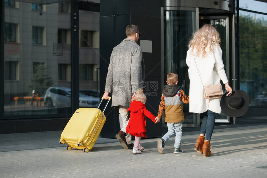 旅游者父亲母亲女儿和子的家属携带黄色手图片