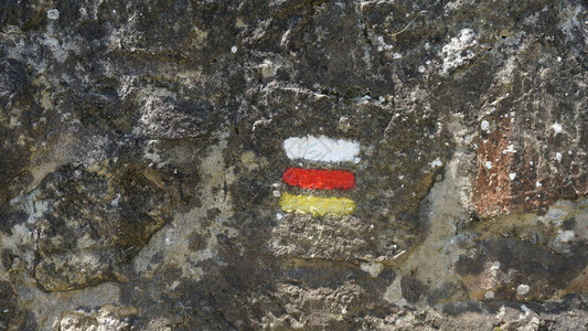 西班牙巴斯克州Gipuzkoa的石墙上涂有圣地亚哥黄卡米诺标志和图片