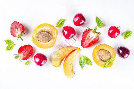 夏季背景与新鲜水果和白色背景上的浆果一套各种时令水果和浆果草莓杏子桃片樱桃薄荷平躺图片