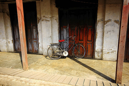 自行车停在旧木门上图片