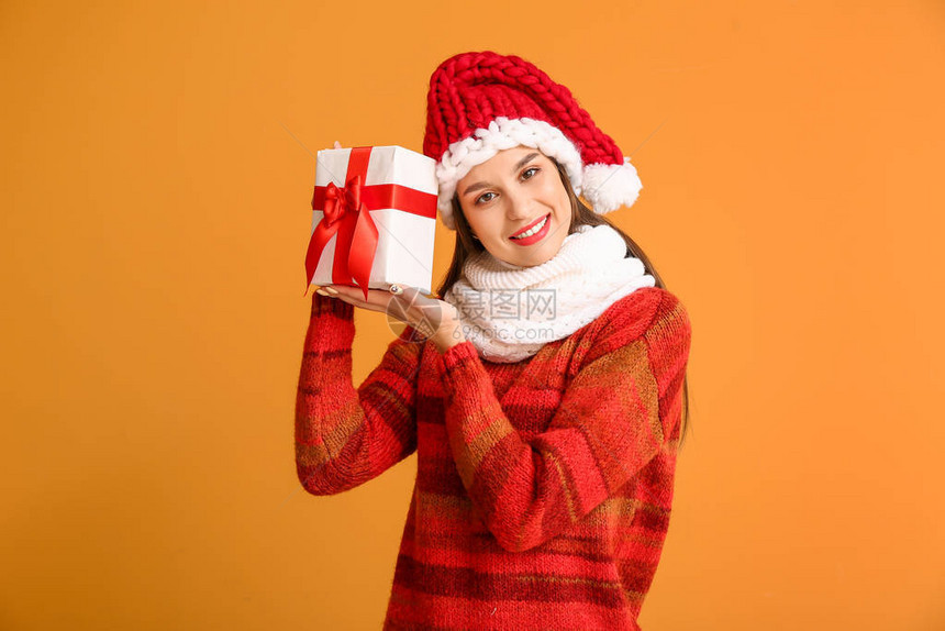 穿着冬衣和圣诞礼物的年轻快乐女人带着彩色背图片