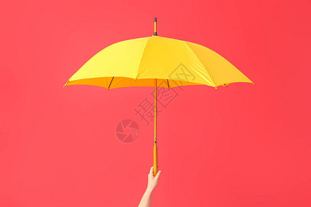 彩色背景上带时尚雨伞的手图片