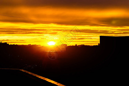 晚上在城市上空的橙色日落城市建筑的高层建筑明亮的灯光建筑城市的剪影图片
