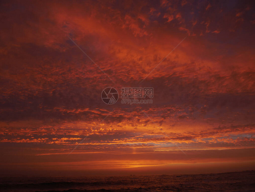沙滩日落时红天在黄昏乌图片