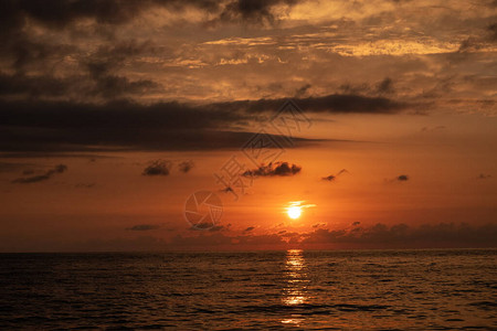 海日落红黄天空蓝云太阳掉入水中晚上好图片