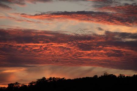 日落时被太阳照亮的红云图片