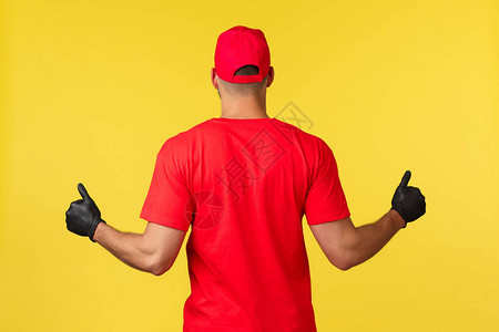 身穿红色制服和手套的强壮男快递员的背部图片