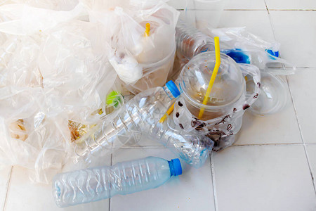 暖菇包把塑料瓶垃圾堆在地板上背景
