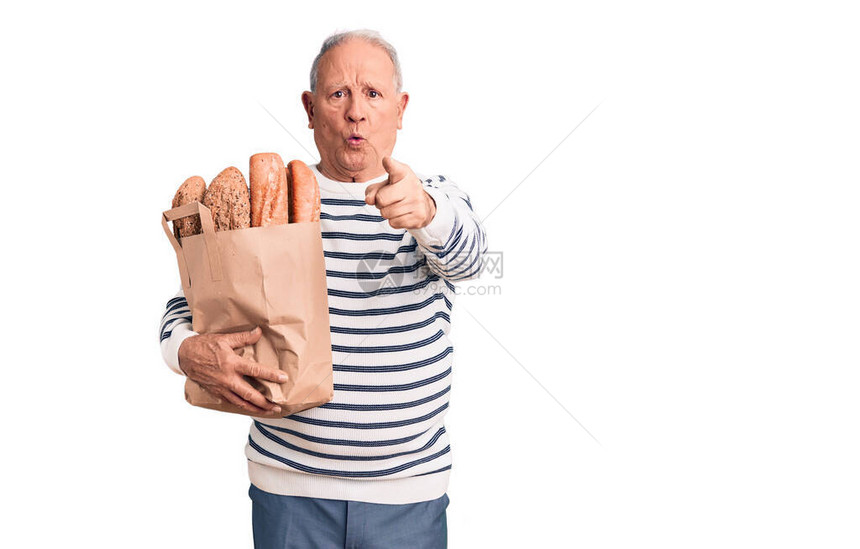 高级英俊的灰发高帅长额灰发男子拿着纸袋和面包图片