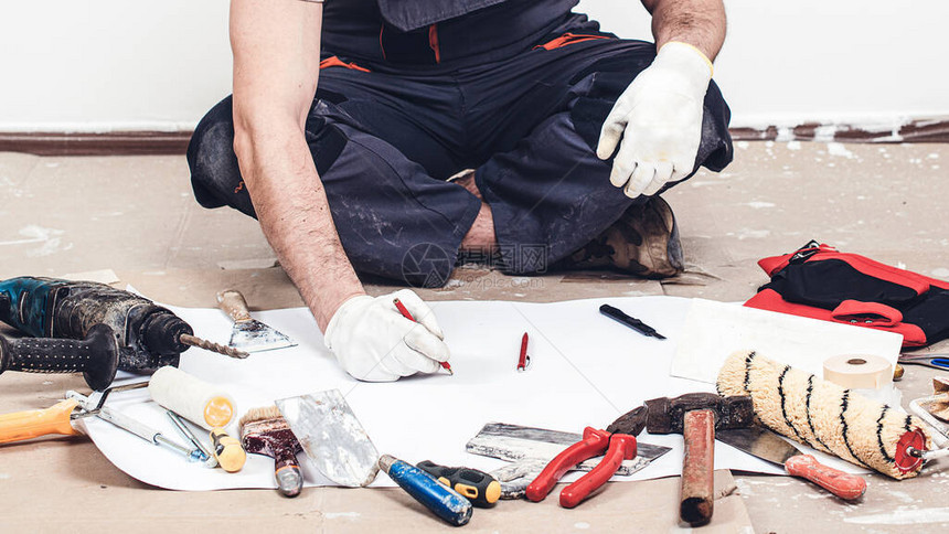 生成器坐在地板上写计划的工人房屋装修服务有施工具的生成器杂工地板上图片
