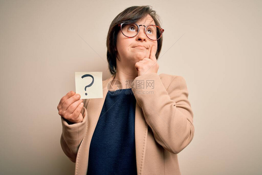 年轻的唐氏综合症女商人拿着问号纸作为怀疑符号严肃的脸思考问题图片