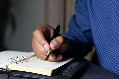 男人的手用笔在纸上书写图片
