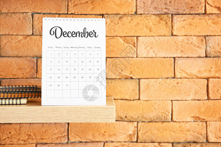 翻页日历砖墙上有翻页纸日历的架子背景