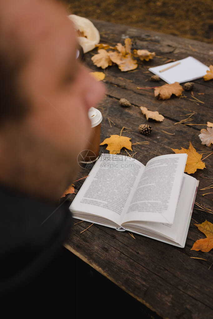 男在秋天公园看一本书图片