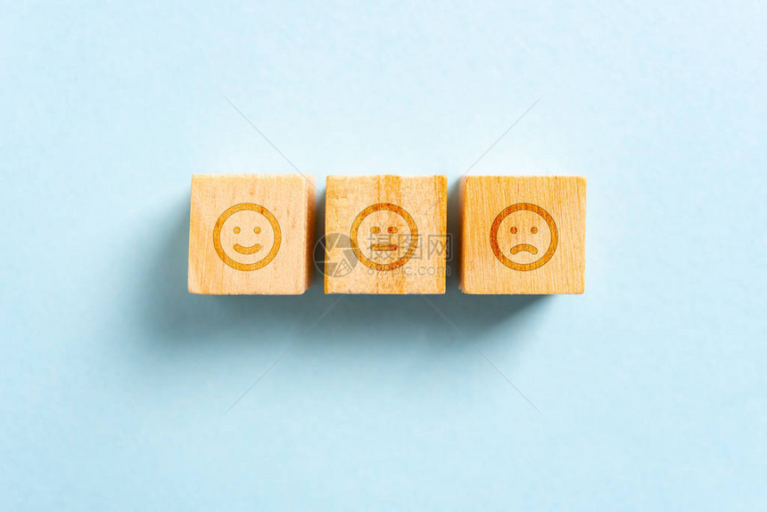在木块玩具和蓝背景上快乐中立和皱眉图片