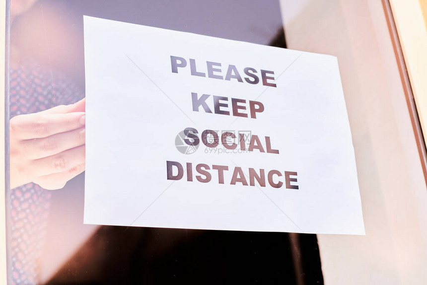 商店或餐馆工作人员挂纸警告请保持社交距离冠状或covid图片