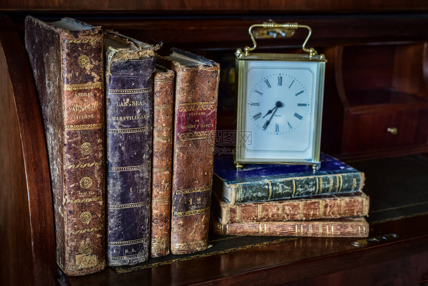 桌子和时钟上的旧书图片
