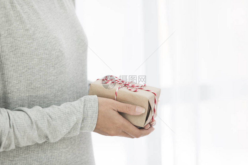 女手拿着小礼物的特写镜头室内女人手中的小礼物浅景深图片