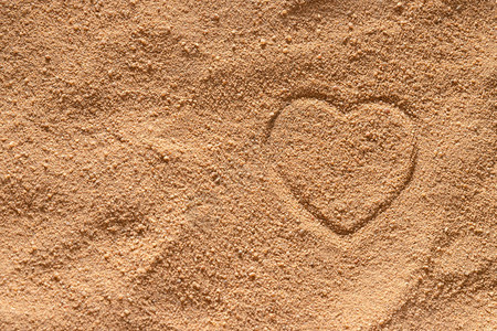 一颗心被画在沙子的表面上图片
