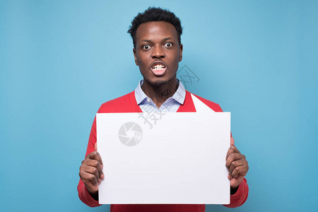 非洲年轻人拿着空白的标语牌为蓝色背景的而战激进主义积极公民社会生活抗图片