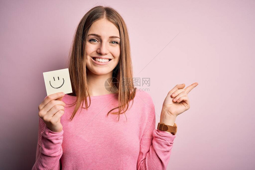 年轻漂亮的红发美女拿着提醒文件带着微笑的面容信息非常快乐地用手和图片