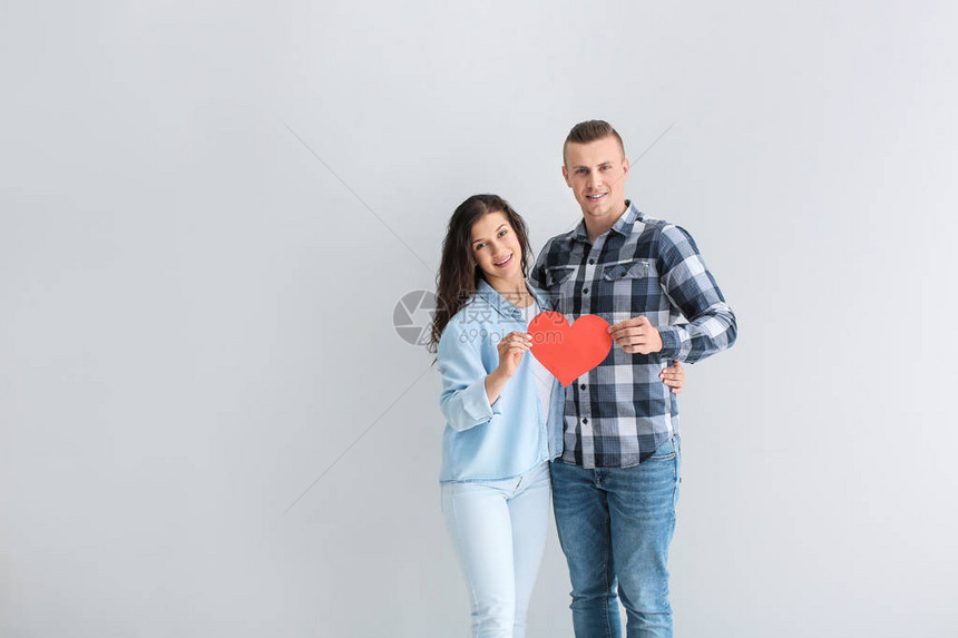 可爱的恩爱夫妻灰色背景上的纸心图片