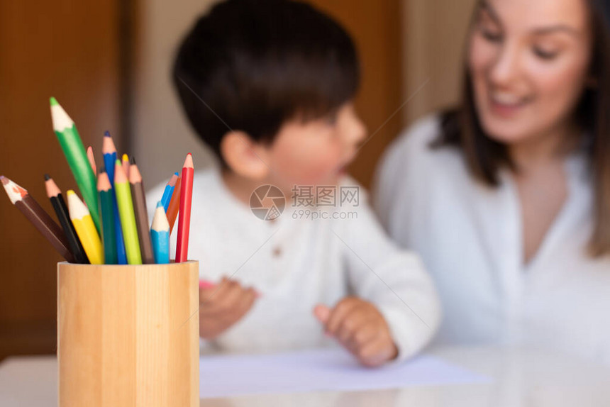 学龄前儿童与母亲或教师育家用彩色铅笔绘图专注于铅笔在家上学习社区图片