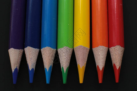 彩色铅笔宏观摄影在亮黑背景下用于创作的背景图片