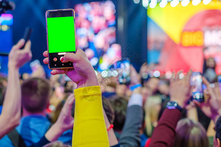 活动观众使用智能手机相拍照录像和现场直播单图片