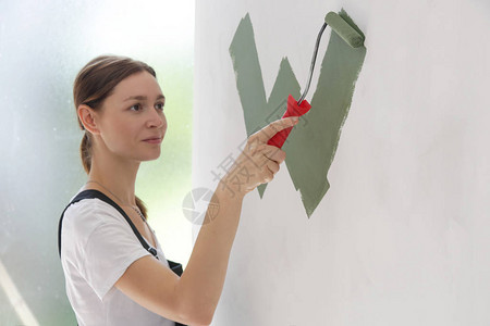 白墙上涂着绿色油漆的女人图片