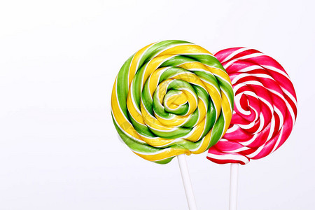 白色背景上的红色和绿色棒糖有条纹的棒糖在白色的棍子上的圆形甜糖图片