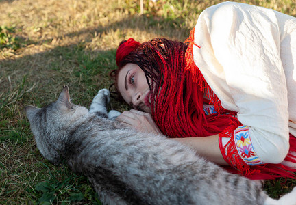 身穿国服躺在草地上与猫玩耍的青春妇女图片