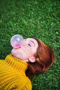 年轻红发女人切腰和制造大气球的头版图片