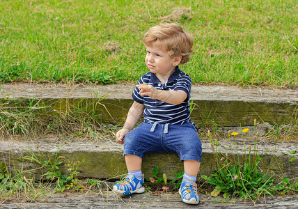 小男孩坐在户外的台阶上图片