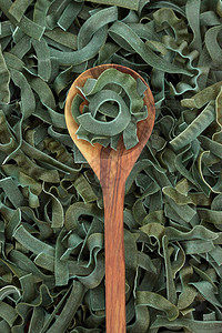 在橄榄木勺上喷发的螺旋状面粉图片