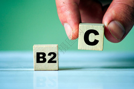 B2C符号在木制立方块上有字手握一个立方块商业图片