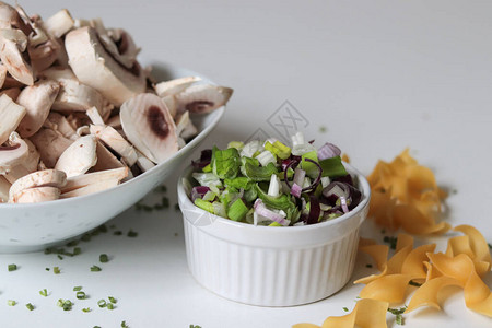 白碗中的春洋葱切片白桌上的蘑菇切片图片