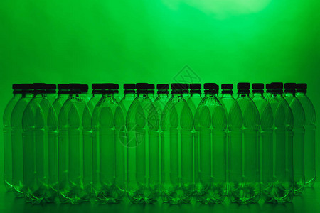 绿色背景上的空塑料瓶剪影图片