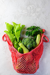 灰色背景的绿色蔬菜字符串袋图片