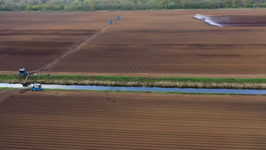 使用中心枢轴喷水灭火系统的鸟瞰作物灌溉机灌溉农田的灌溉枢纽灌溉背景图片