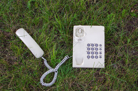 与的交流寓言带接收器的电话位于绿色草坪上鼓励讨论背景图片