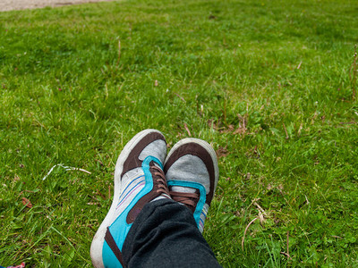人的脚在草坪春天领域的图片