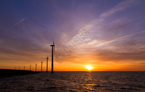 荷兰日落时有多个现代风车涡轮机图片