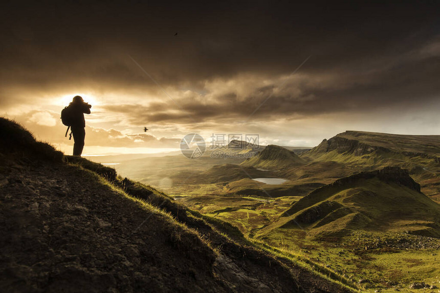 摄影师在英国苏格兰高地斯凯岛拍摄Quiraing山风景的剪影日出时间与背景中五颜六色的ra图片