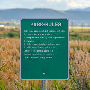 广场绿色标志板与公园规则对抗辽阔地势的平面高草图片