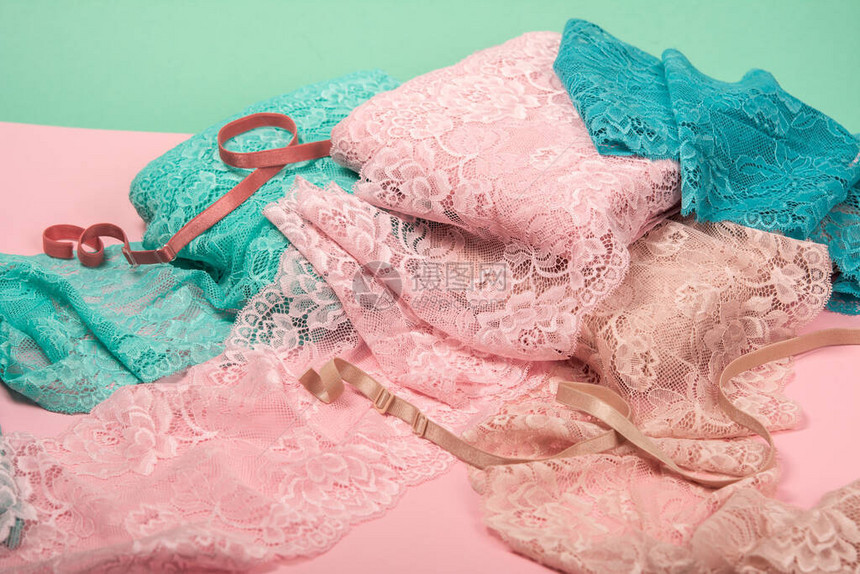 粉红色背景上的内衣内裤和胸罩的彩色蕾丝堆的抽象背景精致迷人的弹材质用于工图片